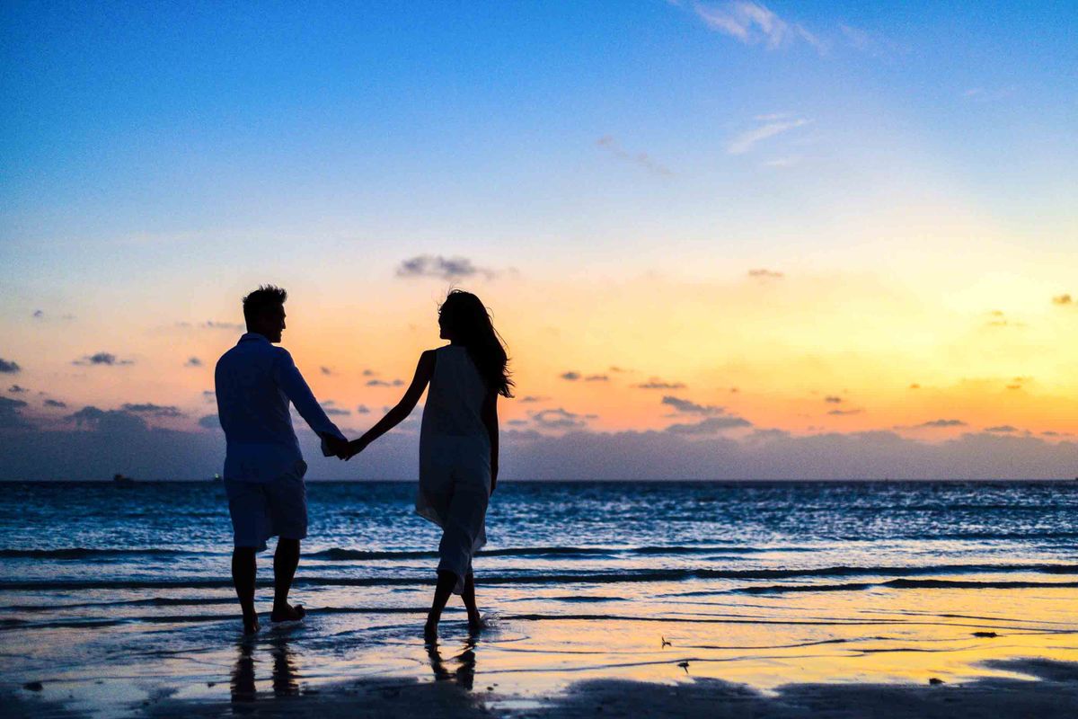 Stel samen bij zonsondergang op het strand